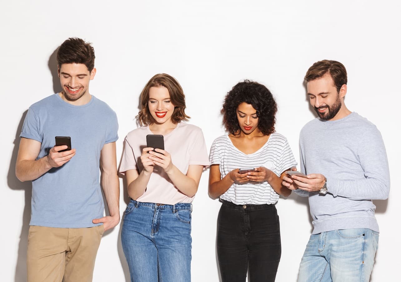 a photo of four poeple holding smartphones that illustrates mobile app marketing guide